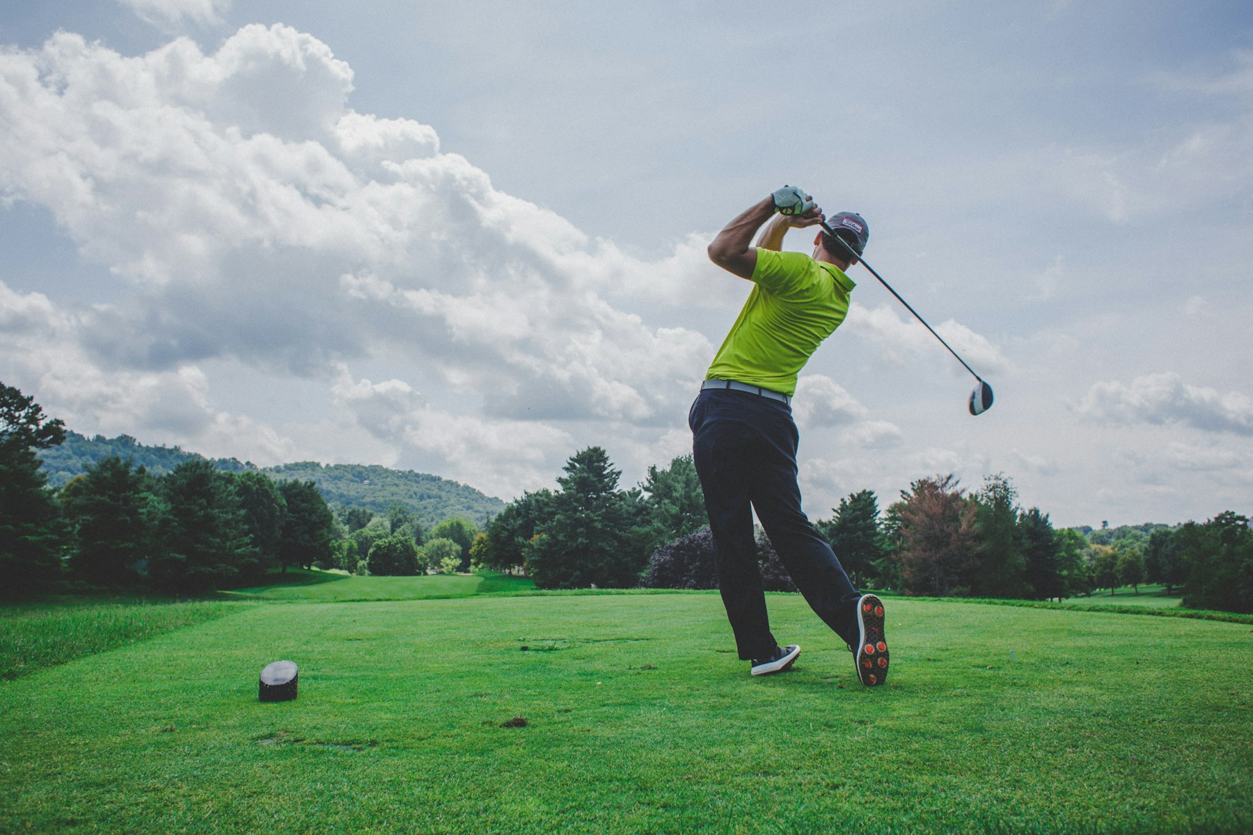 Golfer follow-through on a tee overlooking the fairway